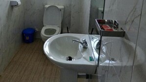 Une salle de bain avec des toilettes, un lavabo et une fenêtre.