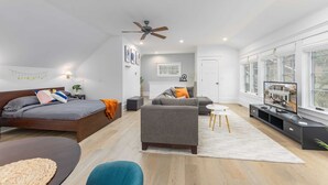 A modern living room with a bed, sofa, and TV area. - Tudor Style Carriage House  (Ann Arbor)