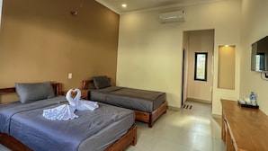 A hotel room with two beds, a wooden desk, and an air conditioning unit. - Areca Muine Homestay (Mui Ne)