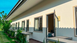 A hotel corridor with multiple rooms, each with a door and a window. - Areca Muine Homestay (Mui Ne)