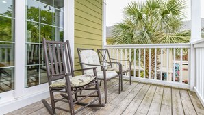 A wooden deck with two rocking chairs and a white railing. - 5 BR Beach House in Surfside Beach with Private Pool! C-Batical (Surfside Beach)