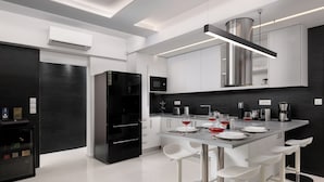 A modern kitchen with a central island, bar stools, and a built-in microwave. - Rhodes Skyline Suite With out Door Jacuzzi Sea View A2 (Rhodes)