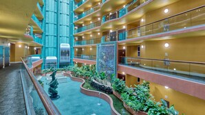 A multi-level atrium with balconies, indoor plants, and a central elevator. - Flash Sale. Caribe D1108. Sleeps 10 (Orange Beach)