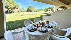 Una mesa preparada para el desayuno con vistas a un área verde y árboles.