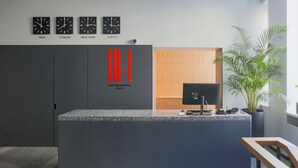 A modern hotel reception desk with clocks displaying times in Riga, London, and New York. - ASTON HOTEL RIGA (Riga)