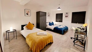A bedroom with two beds, a desk, and a wardrobe. - Modern Apartment in Uxbridge (Uxbridge)