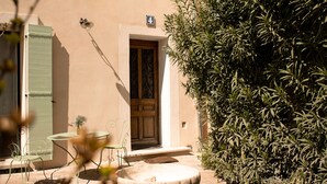 Un bâtiment doté d’une façade en pierre, d’une porte et d’une fenêtre avec des volets.
