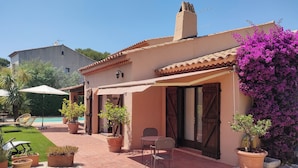 A patio with potted plants, a table, and chairs. - Bienvenue Dans Notre Villa Provençale (Fréjus)