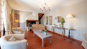 A spacious living room with a wooden coffee table, a sofa, and a chandelier.