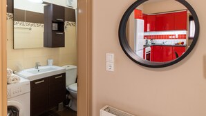 A bathroom with a sink, toilet, and a washing machine.