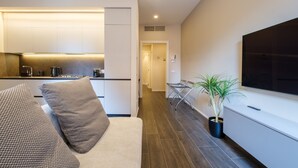 A modern living room with a sofa, a coffee table, and a potted plant. - Golden Suite by Studio Vita (Bologna)