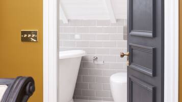 A bathroom with a white toilet, a white bathtub, and a white shower area.