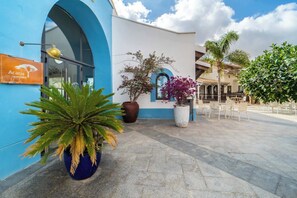 A building with a blue facade, a sign reading "Acacia Trattoria," and outdoor seating with chairs and tables. - Villa with private pool and jacuzzi - EN10LT (Torre-Pacheco)