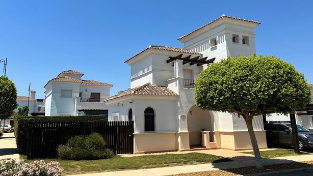 A two-story residential building with a tiled roof, a small balcony, and a well-maintained garden with a single tree. - Villa with private pool & jacuzzi - CA27LT (Torre-Pacheco)