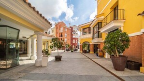 A pedestrian street with buildings, potted plants, and outdoor seating areas. - Villa with private pool & jacuzzi - CA27LT (Torre-Pacheco)