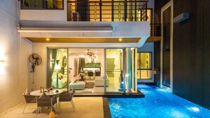 Uma casa moderna com área de estar envidraçada, piscina e mobiliário de jardim.