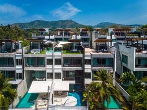 A modern multi-story hotel with a rooftop pool and lush greenery. - Villa Sabine private pool 4br seaview (Rawai)