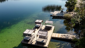 Eine Seeanlegestelle mit klarem Wasser, umgeben von bewaldeten Hügeln.