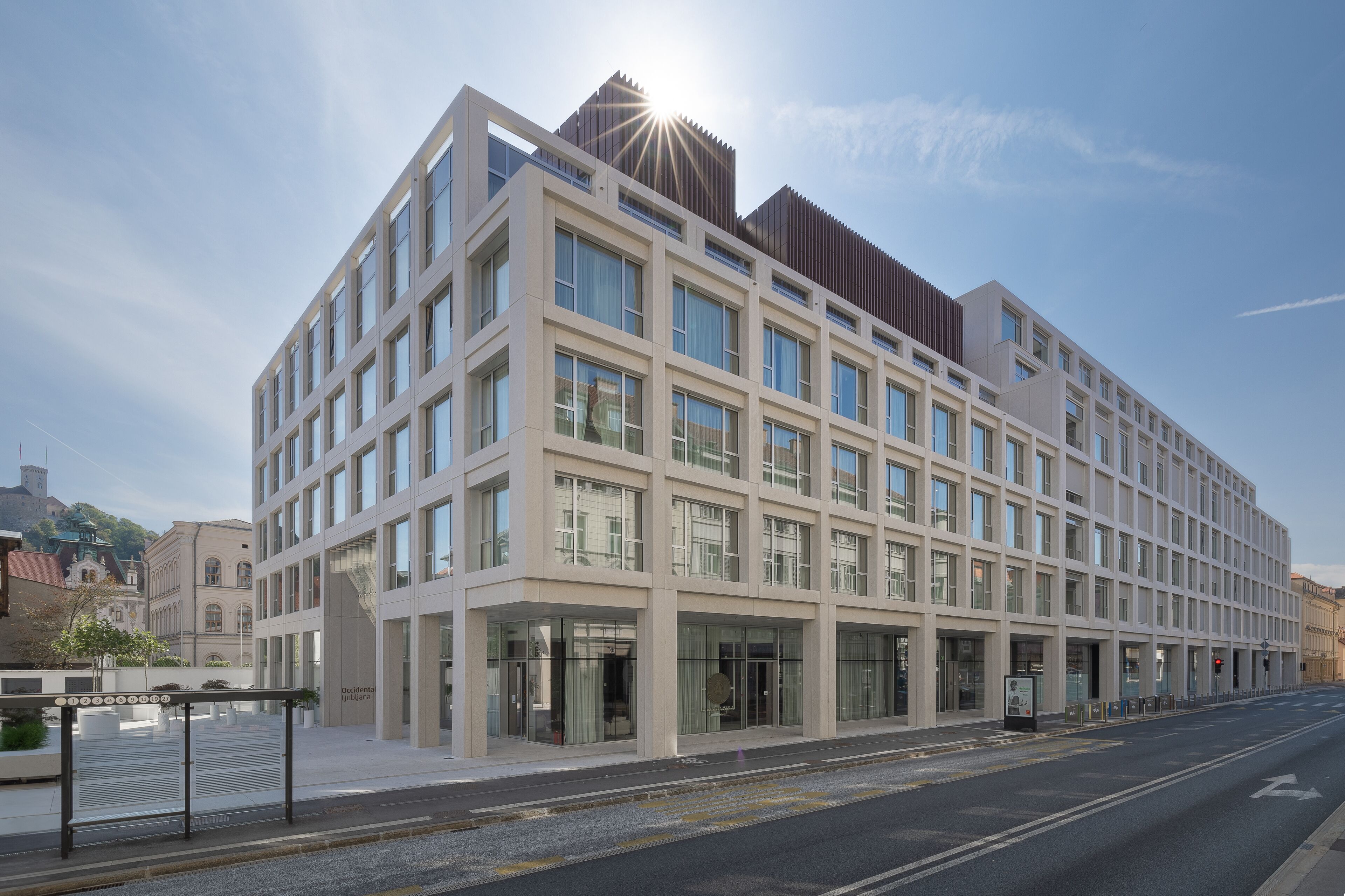 Un edificio moderno de varios pisos con un llamativo frente de vidrio, ventanas amplias y techo plano.