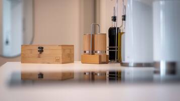 A wooden box, a metal container, and a white bottle on a reflective surface.