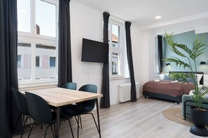 A modern bedroom with a bed, bedside table, and a large window. - nestup Hildesheim Zentral (Hildesheim)