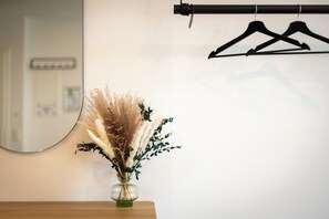 A mirror, a vase with dried pampas grass, and a wooden dresser. - BRIGHT Hildesheim Angoulemeplatz (Hildesheim)
