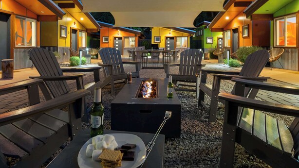 Un'area patio con posti a sedere all'aperto, un braciere e un tavolo da pranzo imbandito.