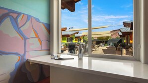 A room with a window overlooking a colorful outdoor area with buildings and a clear sky. - Downtown Moab • Hot Tub • Walk to Dining & Trails (Moab)