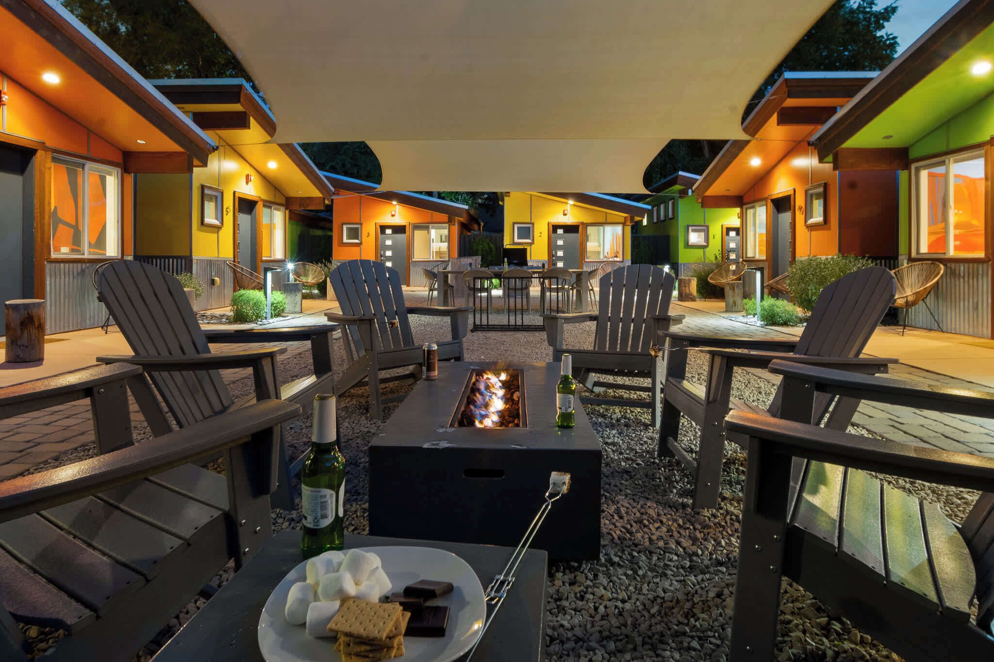 En uteplats med utemöbler, en eldstad och ett matbord med mat på.