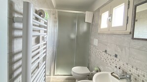 A modern bathroom with a walk-in shower, a toilet, and a sink. - bed and book (Rimini)