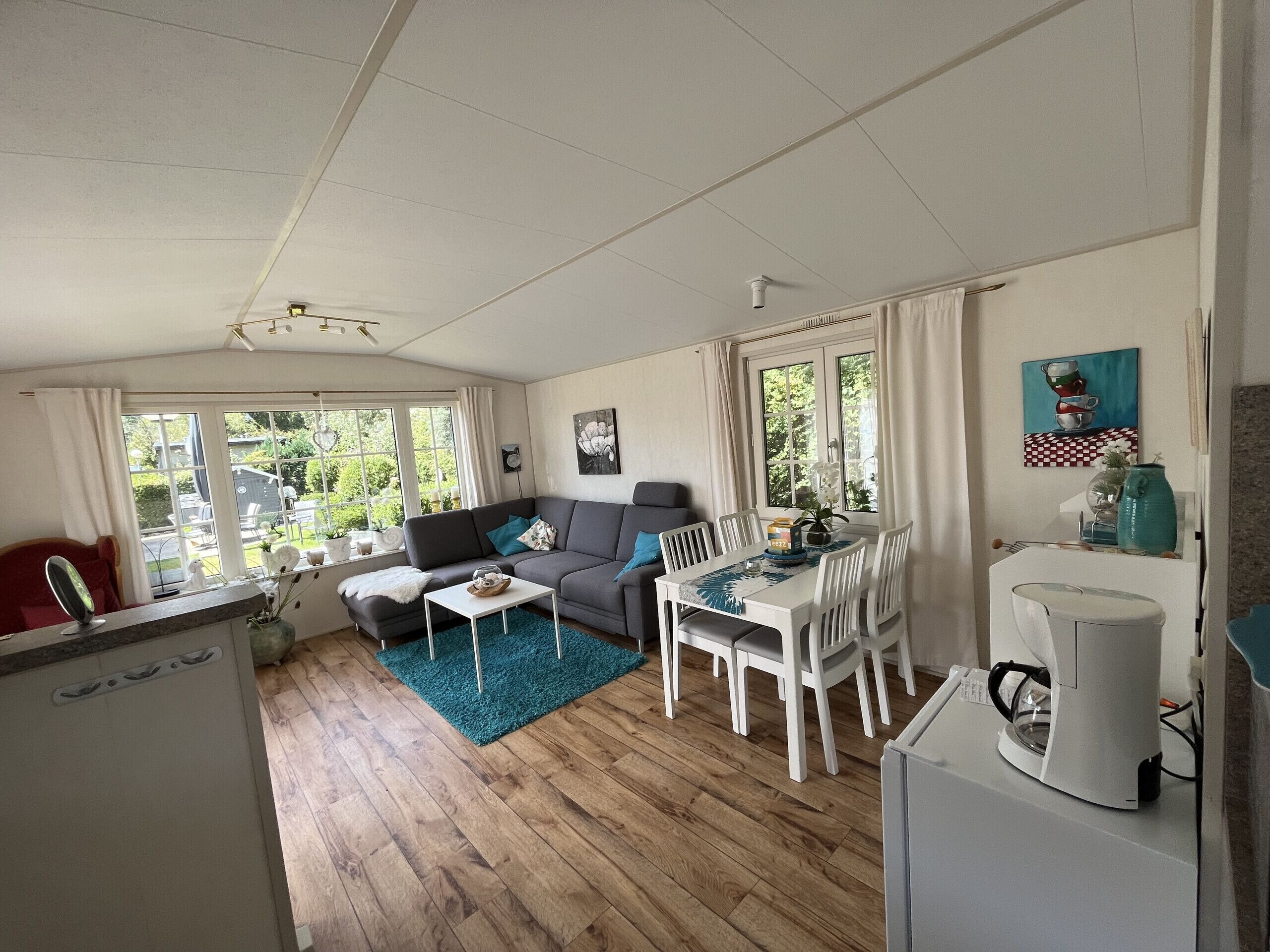 A cozy living room with a sofa, dining table, and coffee machine.