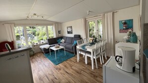 Un salon confortable avec un canapé, une table à manger et une machine à café.