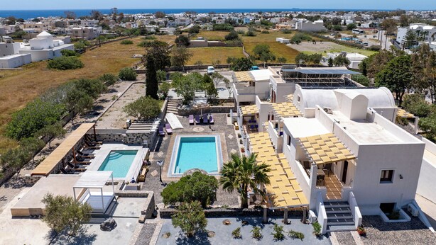 Um resort com várias piscinas, um terraço no telhado e vista para o mar.