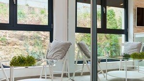 A modern room with large windows, white furniture, and a view of greenery outside. - Hedera Estate, Hedera Studio 4 (Dubrovnik)