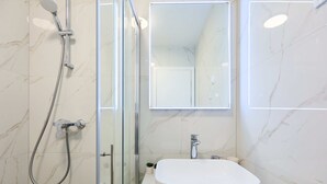A modern bathroom with a glass shower enclosure, a white sink, and a mirror above the sink. - Hedera Estate, Hedera Studio 4 (Dubrovnik)
