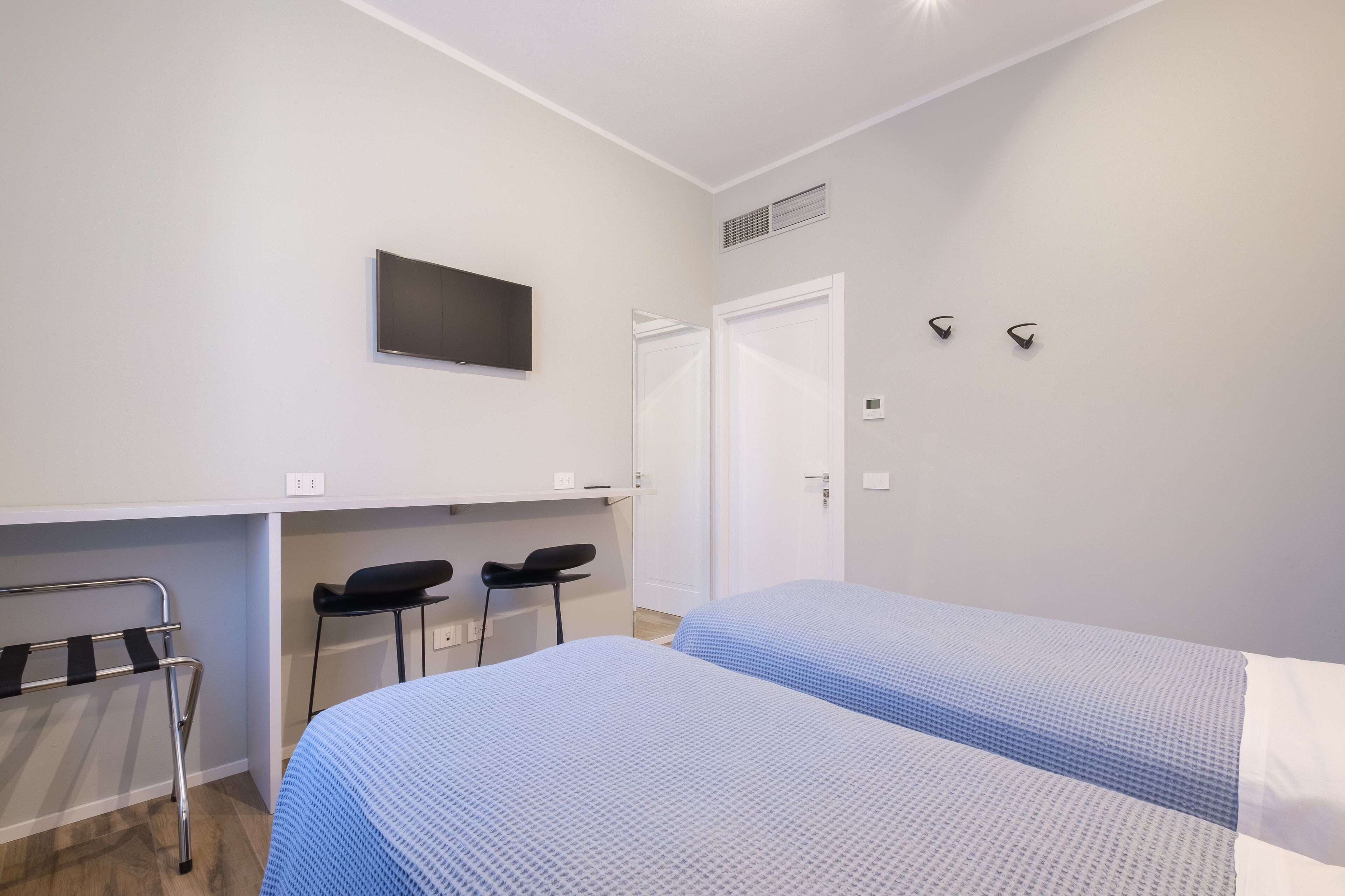 Un dormitorio con dos camas, un escritorio y una silla.
