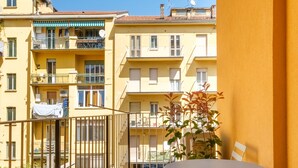 Un balcon avec du gazon synthétique, une table et des chaises.