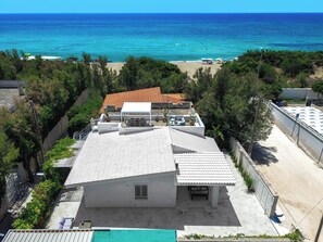 Un edificio con tetto in tegole, un'area patio e vista sull'oceano.