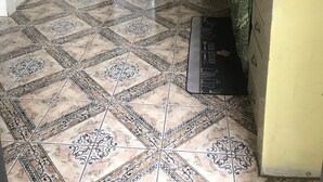 A kitchen with patterned tiles, a stove, cabinets, and a microwave. - B&B rent rooms  (Chaguanas)