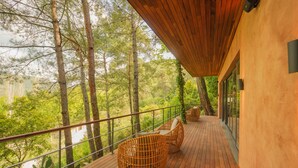 A wooden deck with wicker chairs overlooking a forested area. - Nuup Hotel (Marmaris)