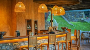A bar area with stone walls, wooden chairs, and hanging wicker lamps. - Nuup Hotel (Marmaris)