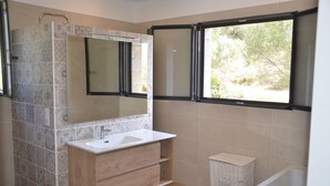 A bathroom with a wooden vanity, a sink, a mirror, a window, and a bathtub. - Haut de Villa, Calme, vue mer (Serra-di-Ferro)