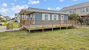 A single-story house with a covered porch and a wooden deck. - The Saltbox-Home in Atlantic Beach (Atlantic Beach)
