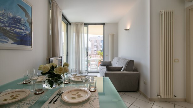 Een eethoek met een tafel voor vier personen, een bank en een radiator.