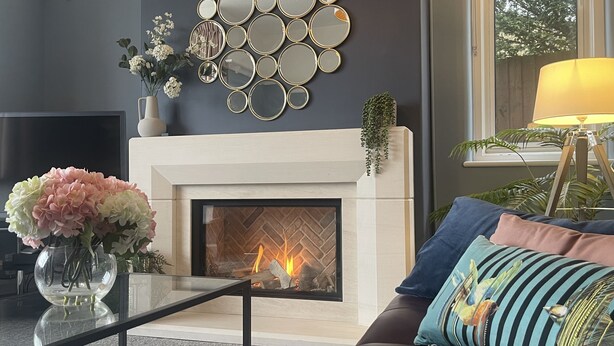 A modern living room with a fireplace, a wall-mounted mirror art piece, and a sofa with decorative pillows. - Winterstoke View, Family and dog Friendly Beach Retreat (Ramsgate)
