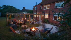 A backyard with a fire pit, seating area, and a hammock. - Winterstoke View, Family and dog Friendly Beach Retreat (Ramsgate)