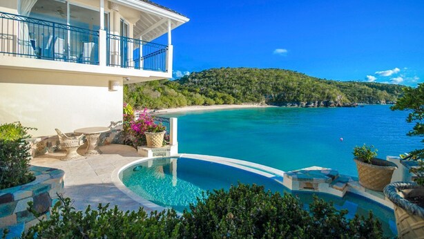 A modern house with a pool, a balcony, and a view of the sea. - Blue Waters Resort - Rock Cottage (Antigua and Barbuda)