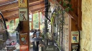 A rustic wooden building with a stone wall, a welcome sign, and multiple Le Routard recommended signs from 2020 to 2026. - Studio-Mountain view-Wet room-Romantic (Aleu)