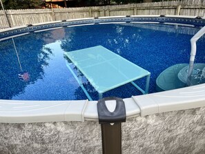 A swimming pool with a tiled edge, a pool table, and a water fountain. - Comfortable 4 bedroom home in South Tulsa (Tulsa)