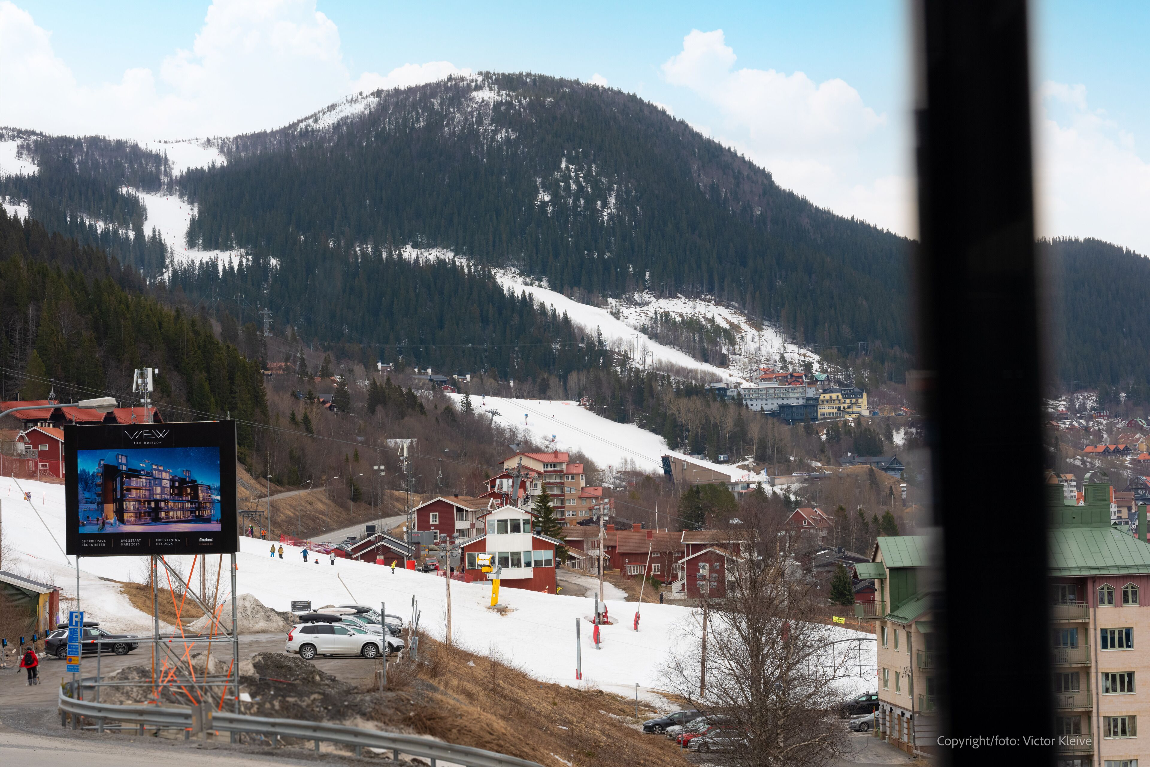 Un hotel con vistas a una montaña nevada y una pista de esquí.